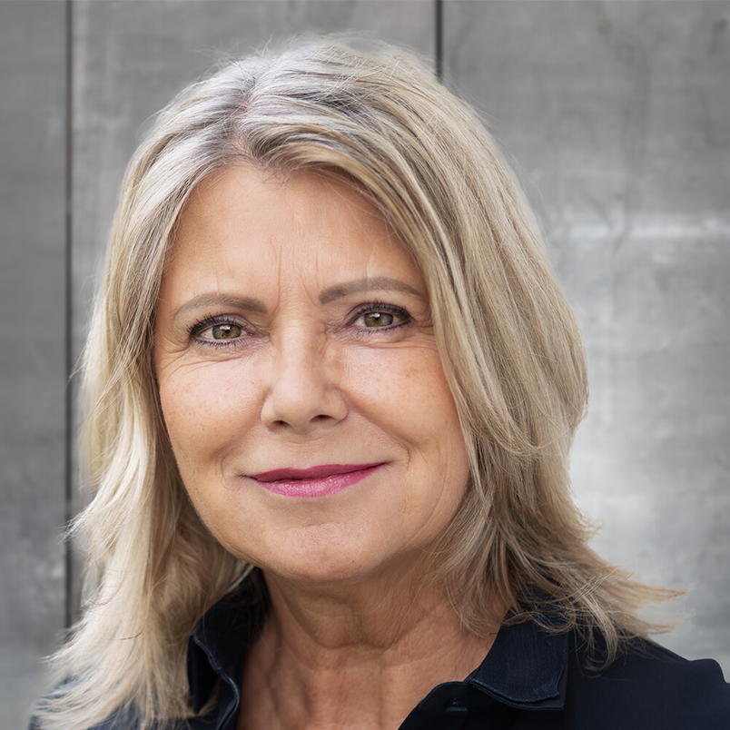 Profilbild Bettina Ploberger vor grauer Wand