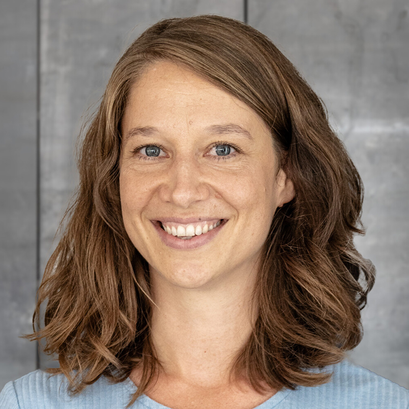 Profilbild von Teammitglied Jana Brettner vor grauer Wand