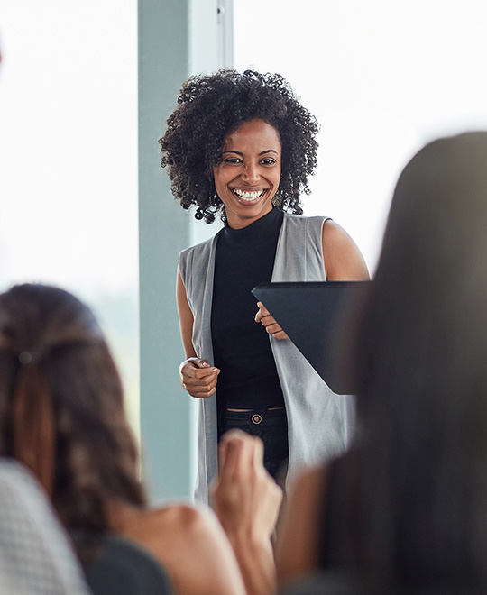 Frau pr&auml;sentiert etwas und lacht dabei