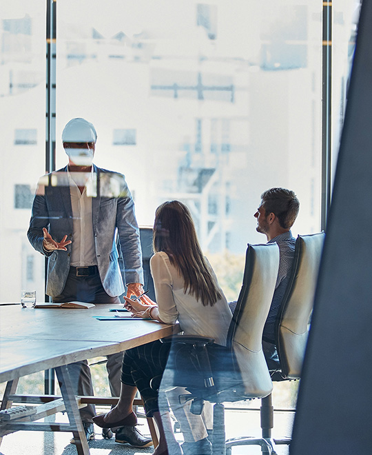 Drei Personen unterhalten sich in einer Besprechung