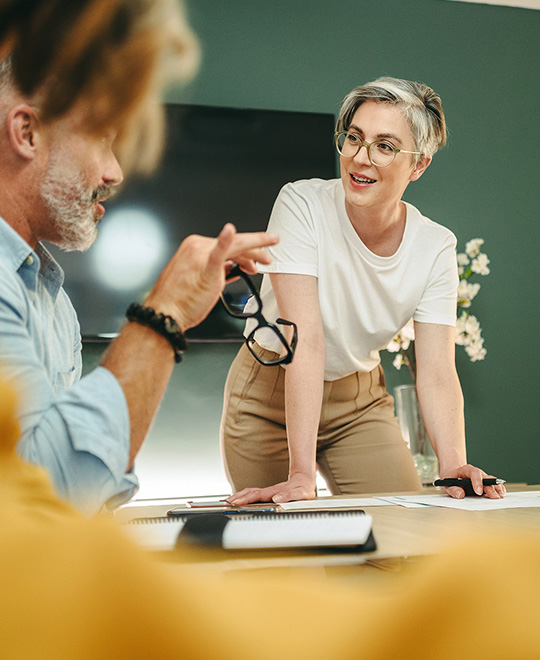 Drei Personen unterhalten sich in einer Besprechung