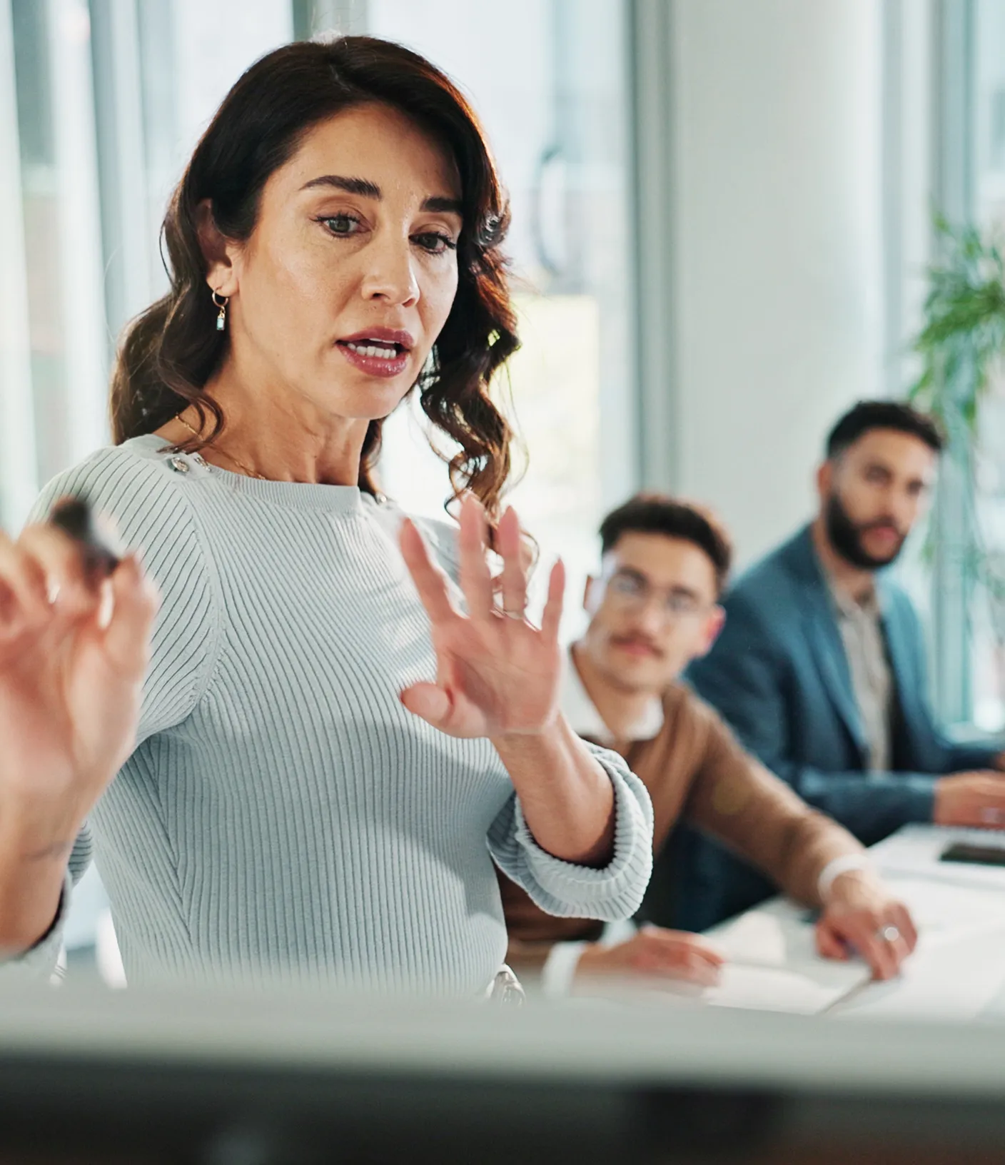 Frau mit dunklen langen Haaren erkl&auml;rt ein Konzept anderen Menschen