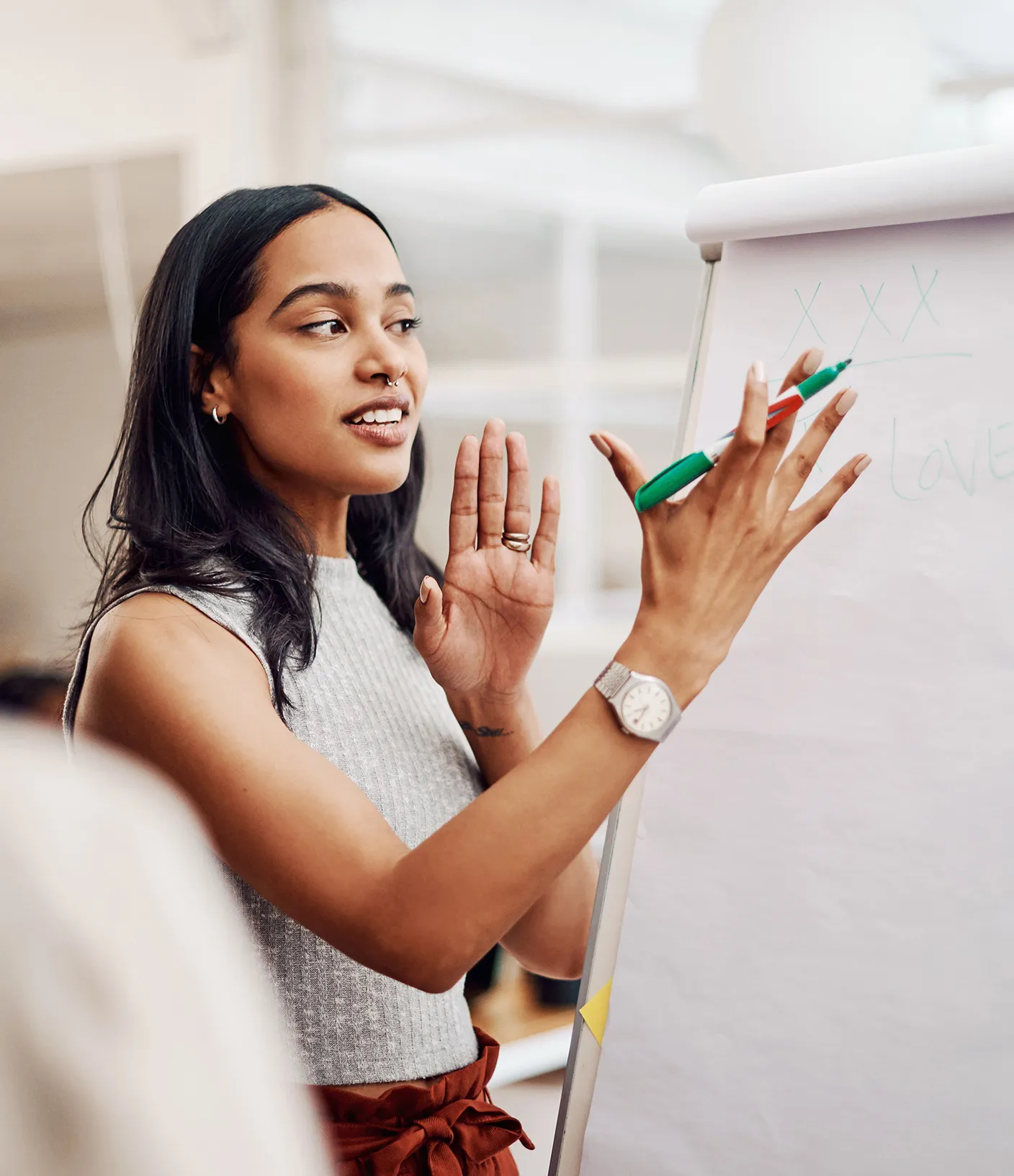 Frau steht vor Whiteboard und erkl&auml;rt etwas