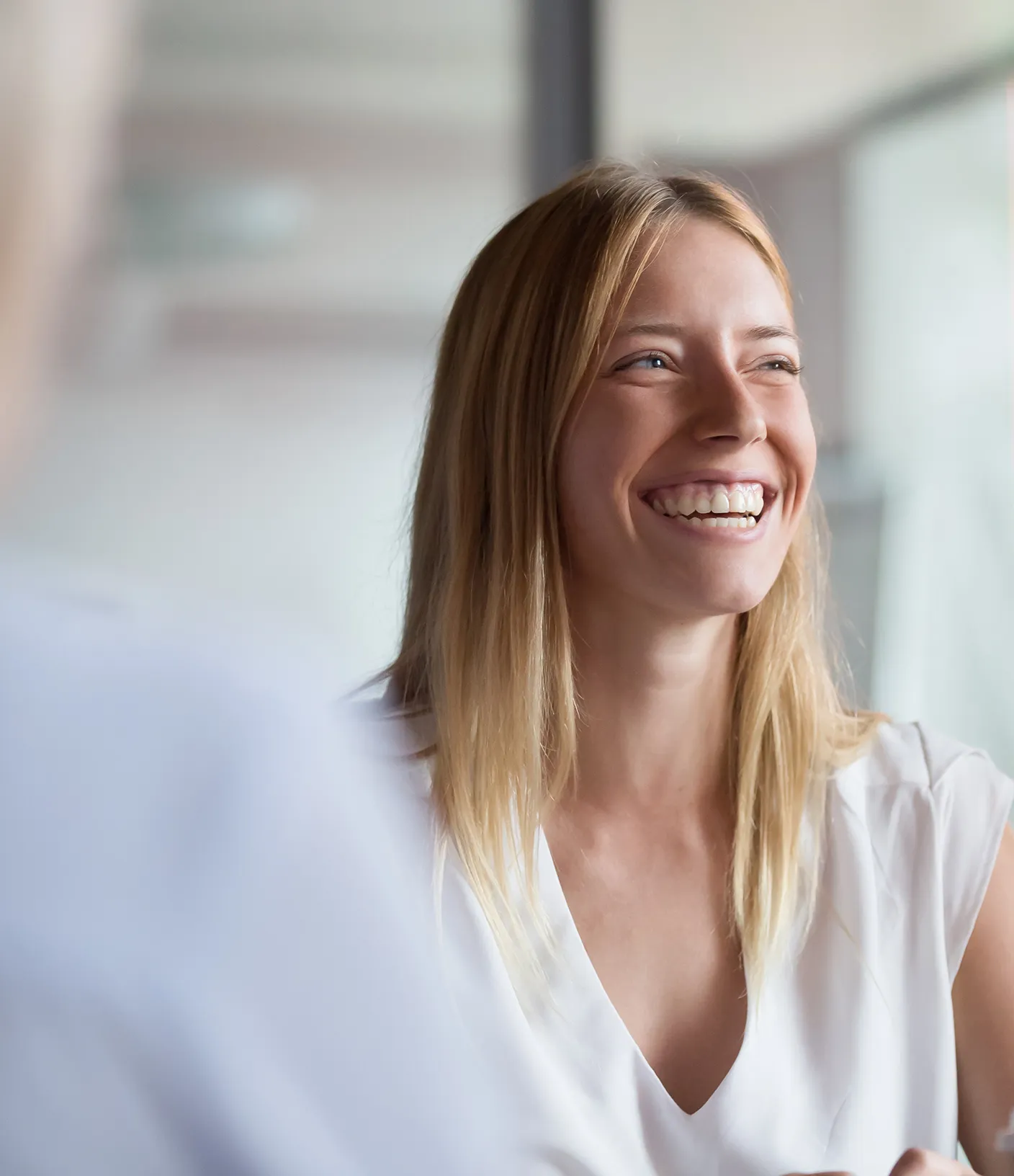 Lachende blonde Frau in wei&szlig;em T-Shirt